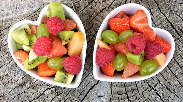 Zwei herzförmige Schalen mit geschnittenem Obst und Früchten