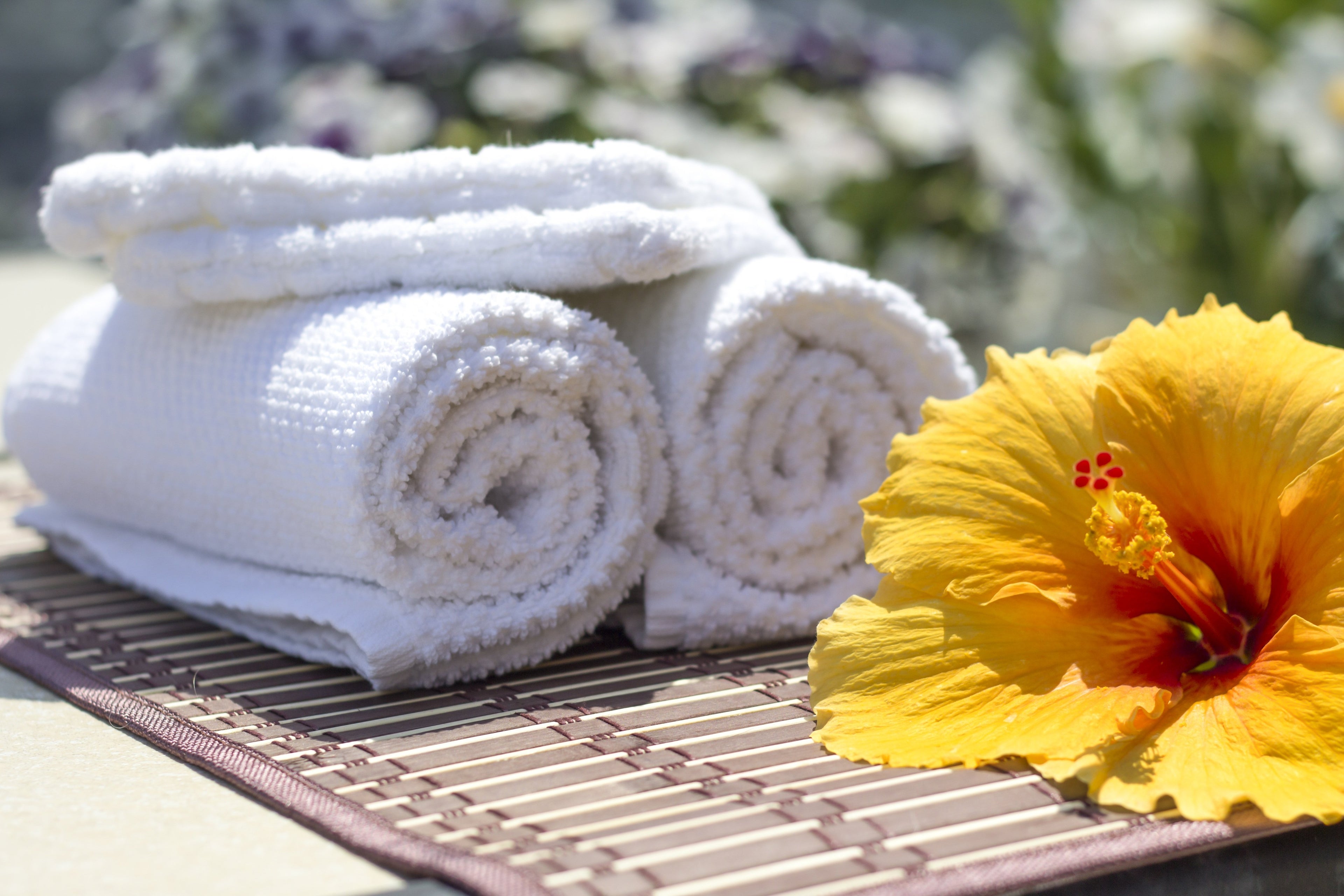 Handtuch und Blume auf Matte im Freien