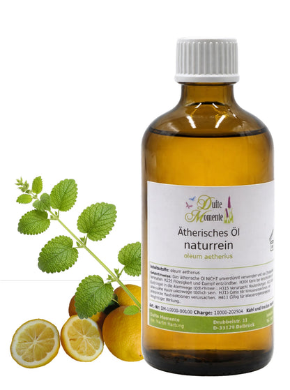100-ml-Flasche der ätherischen Ölmischung Melisse-Zitrone von Dufte Momente mit Melisseblättern und Zitronen auf weißem Hintergrund