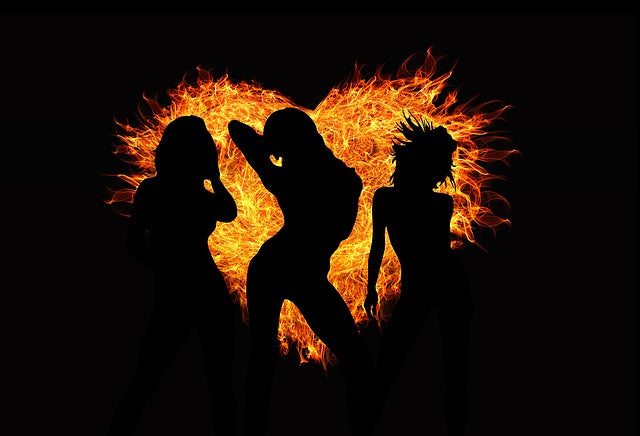 Silhouetten tanzender Frauen vor einem Feuerherz