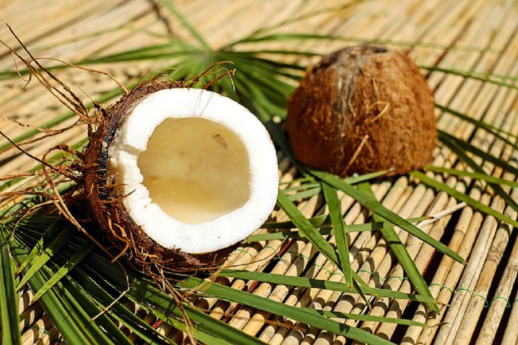 Eine gespaltene Kokosnuss auf einer Bambusmatte