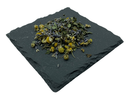 Kräutermix getrocknete Kamilleblüten, Lavendel, Melisse und Pfefferminz auf Schiefertafel