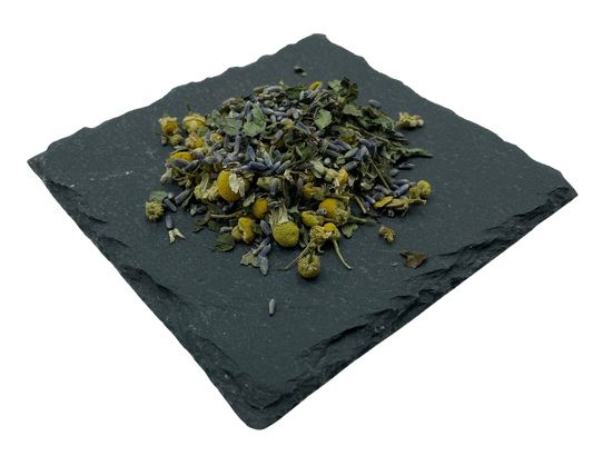 Kräutermix getrocknete Kamilleblüten, Lavendel, Melisse und Pfefferminz auf Schiefertafel