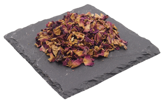 Getrocknete Rosenblüten auf Schiefertafel